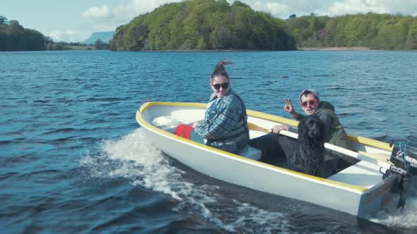 Two youths lake adventure in small outboard boat with adorable dog