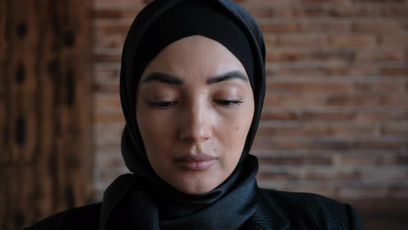 Young Muslim Woman in Hijab Raises Her Hand and Prays