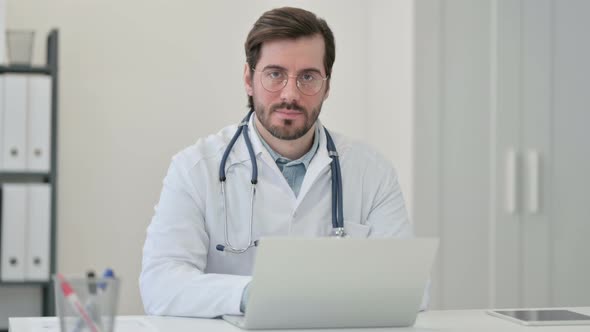 Young Male Doctor Laptop Looking Camera