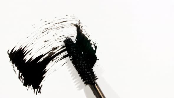 Macro Shot and Slow Motion of a Black Mascara Isolated on White Background