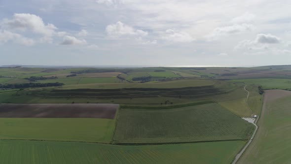 Aerial tracking forward towards Maiden Castle from Dorchester. The wide shot that encompasses the wh