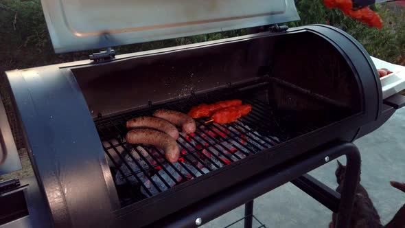 Putting Chicken Sate on the grill. Next to the cooking Sausages. This is one good looking Summer BBQ