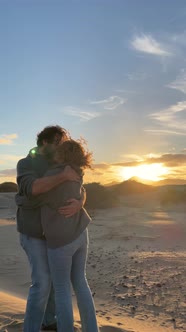 Romantic couple with man and woman and looking each other enjoying a coloured sunset in outdoor