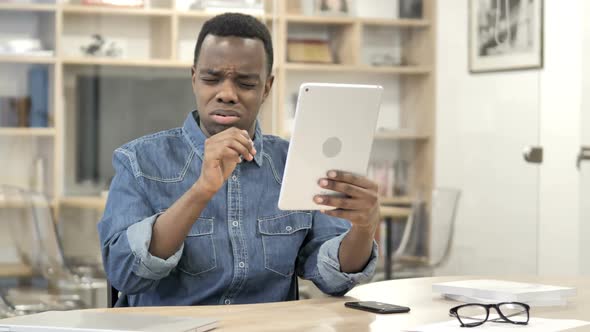 AfroAmerican Man Reacting to Loss While Using Tablet