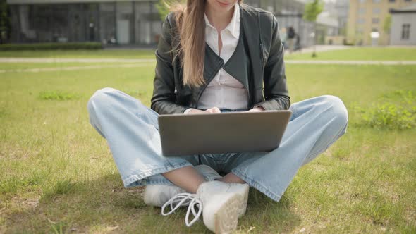 Happy Woman Working on Laptop Computer on Green Lawn in Summer Park