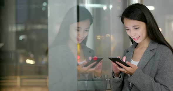 Business Woman Look at Smart Phone with Window Reflection at Night