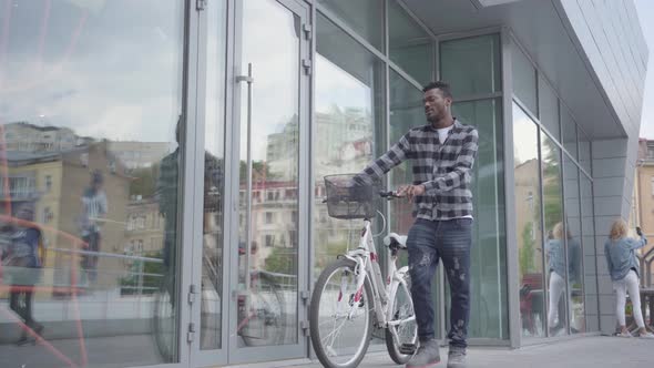 Portrait Confident Handsome African American Man Standing with Bicycle Against the Background