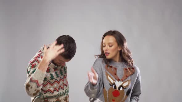 Happy Couple in Christmas Ugly Sweaters Dancing 20