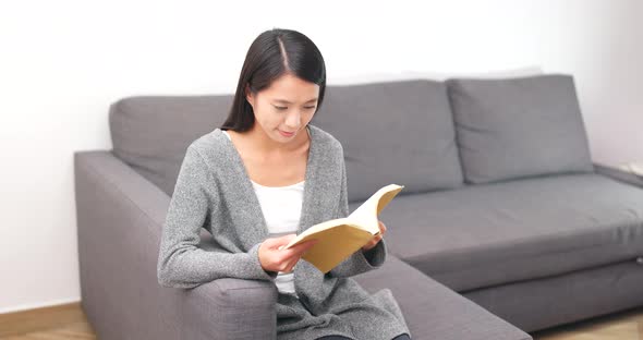 Woman reading book at home