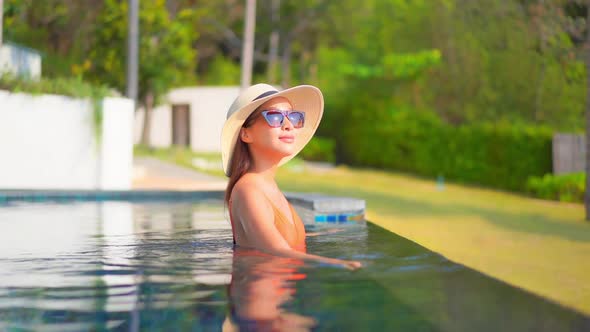 Young asian woman enjoy around outdoor swimming pool for leisure