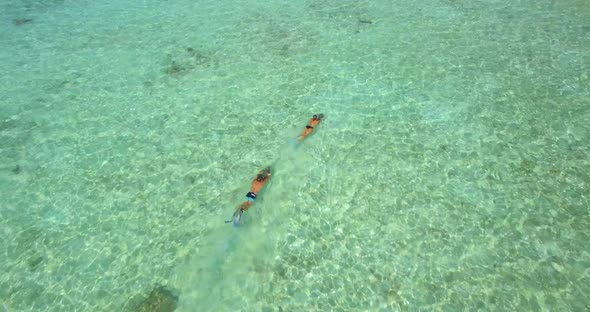 Aerial drone view of a man and woman couple snorkeling with seascooters.