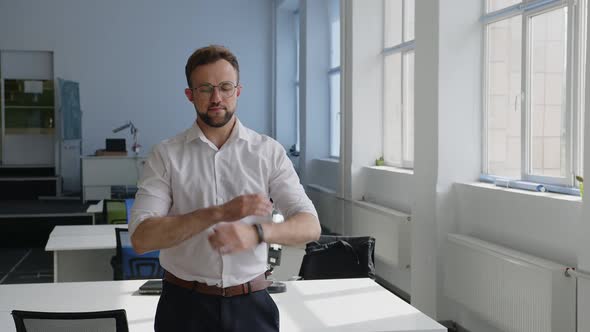 Office Worker Stands and Crosses His Hands