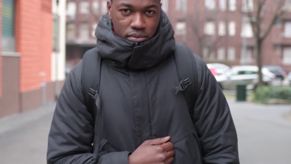 portrait of young african man standing in the street and smiling