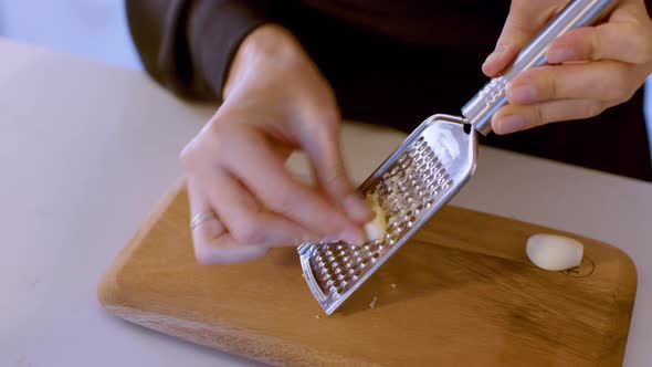 Fresh Garlic Clove Crushed In The Grater On The Wooden Cutting Board Macro