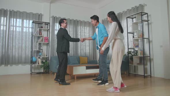 Asian Real Estate Agent Shaking Hands With A Man Before Talking About The House For Sale