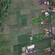 drone view of residential settlements around green rice fields - VideoHive Item for Sale
