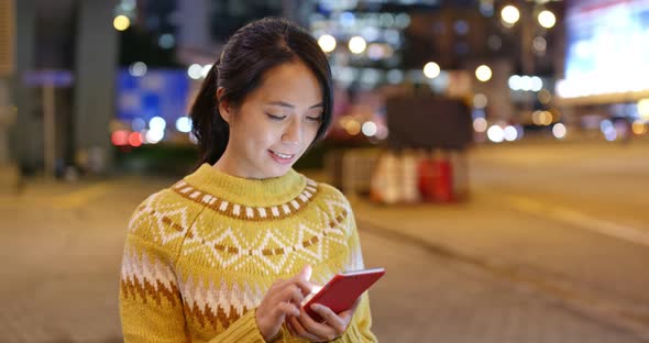 Woman Read on Mobile Phone in City at Night