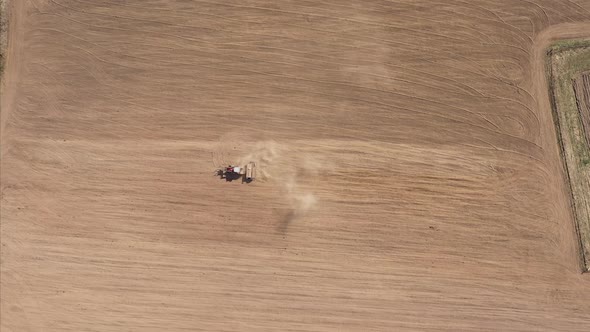 Aerial Tractor With Seeder Plowing An Empty Field