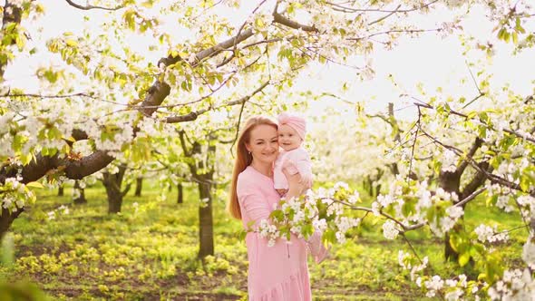 Mother with Baby in Arms in Flowering Garden