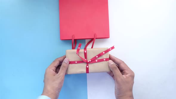 Hand in Latex Gloves Wapping a Gift Box with Tissue