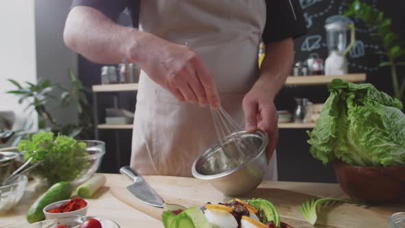 Man Stirring Sauce with Whisk