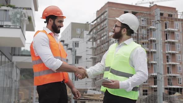 Construction Manager and Workers Shaking Hands on Construction Site. Professions, Construction