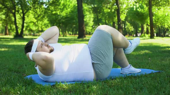 Fat Man Diligently Exercising in Park, Abs Workout, Strong Desire to Lose Weight