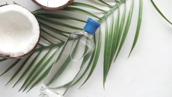 Slice of Fresh Coconut and Bottle of Oil on a Table