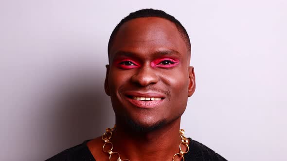 Afro American Man in Dress Style with Pink Eyeshadow and Lipstick Crossdressing in Fashion Show