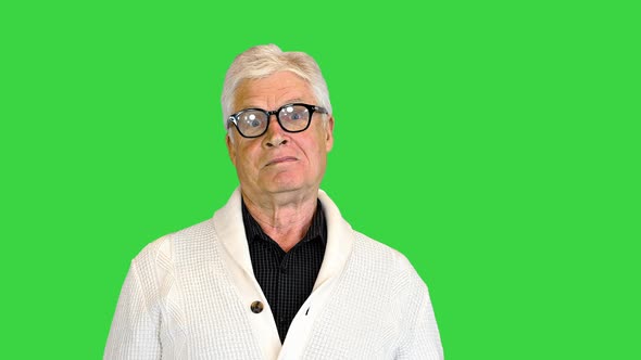 Happy Aged Man Shows a Greeting Sign on a Green Screen Chroma Key