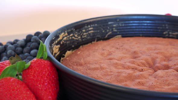 A Cake Base in a Form and Fruit on a Kitchen Counter - Closeup