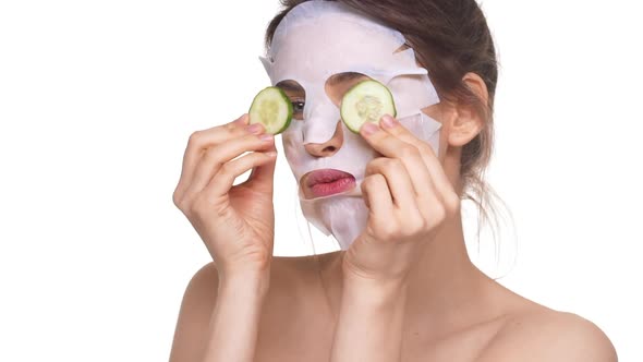 Beautiful Caucasian Female with Facial Mask Having Fun Over White Background in Slowmotion