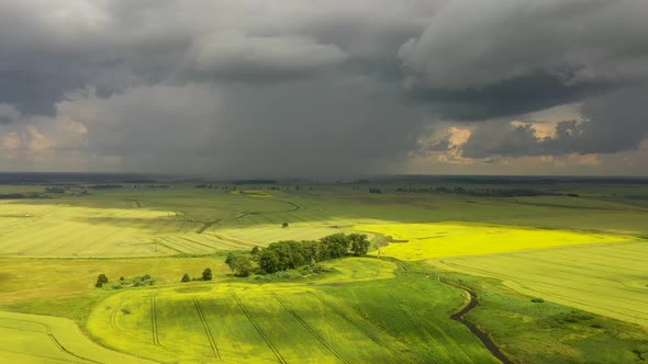 The storm clouds over the agricultural fields, view from a drone
