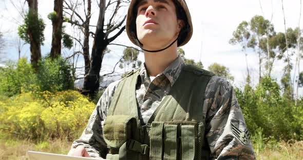 Military soldier using digital tablet during training exercise