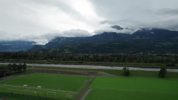 Liechtenstein with Houses on Green Fields in Alps Mountain Valley Aerial View