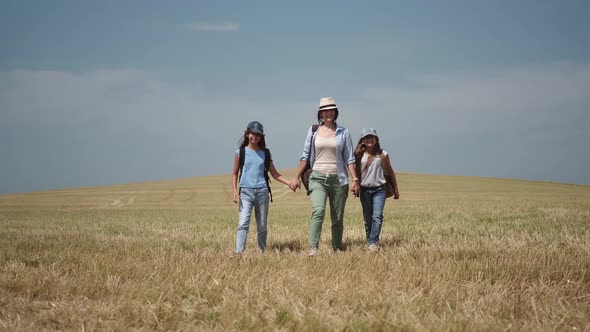 Family of Travelers Is Walking on a Hill. Mother Leads Her Young Children on a Hike.