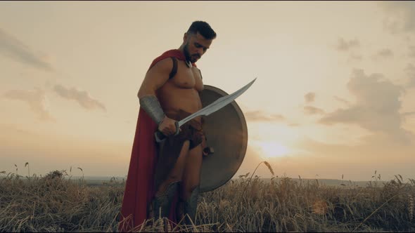 Shirtless Spartan Twisting Sword in Dry Field.