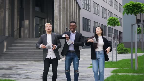 Young Multiracial Mates which Throwing Up Money Over their Heads and Dancing in the Street