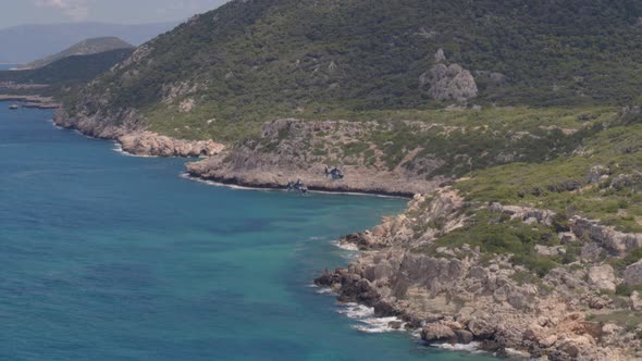 Private Helicopters Flying by Mountains and Rocks Cascading into the Ionian Sea