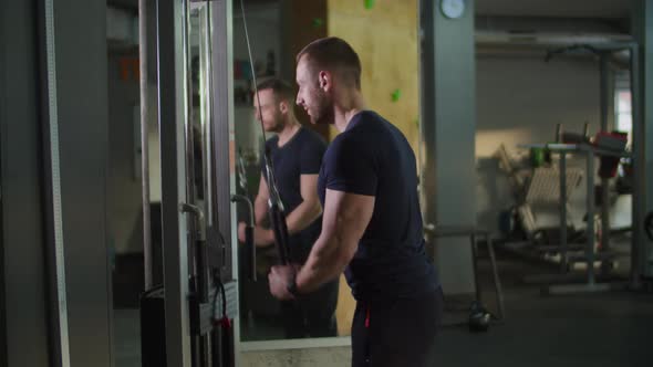 Man Doing Triceps Rope Pushdown Exercise in Gym.