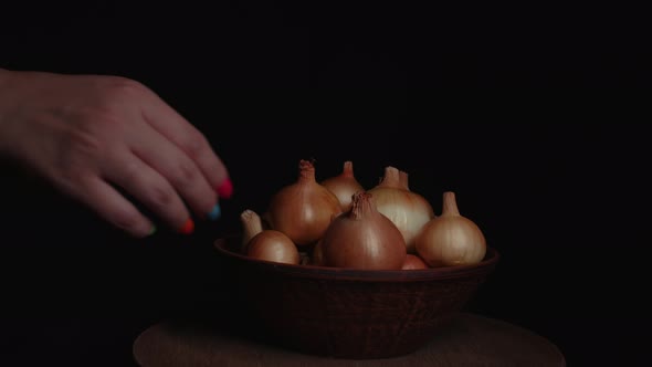 Pile of Whole Bulbs of Raw Onion in Ceramic Bowl on Table