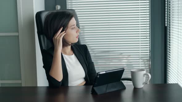 Young Business Lady Sitting Behind the Desk with Tablet Shaking Head Being Dissapointed and Tired