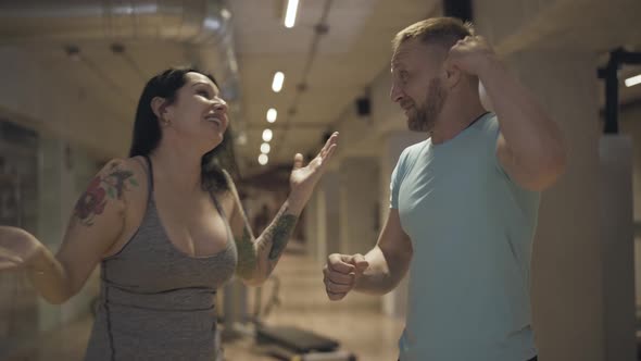 Strong Healthy Man and Woman Giving High Five and Leaving. Portrait of Happy Smiling Caucasian