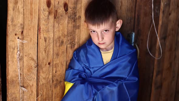 war russia against Ukraine. crying Ukrainian boy with the flag of Ukraine outdoors. Stop war.