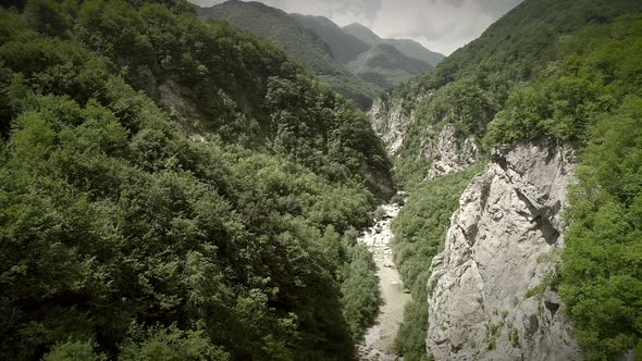 Aerial view of a person riding on zip line flying through the forest in Slovenia