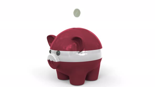 Coins Fall Into Piggy Bank Painted with Flag of Latvia alt