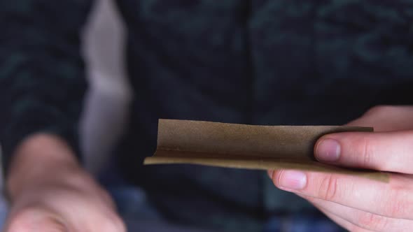 Close Up Marijuana Joint with Lighter. Man Rolling Marijuana Cannabis Blunt. Man Rolling a Marijuana