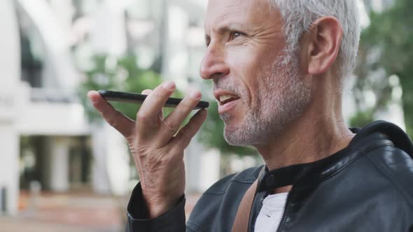 Caucasian man out and about in the city street talking on his smartphone