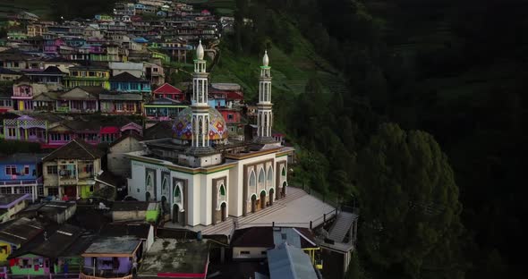 Drone shot of famous Masjid Baituttaqwa Mosque surrounded by green nature and colorful buildings on
