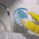 Young Woman in Yellow Rubber Gloves in the Kitchen is Washing Dishes By Hand - VideoHive Item for Sale